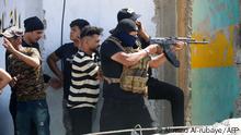 An armed member of Saraya al-Salam (Peace Brigade), the military wing affiliated with Shiite cleric Moqtada al-Sadr, fires during clashes with Iraqi security forces in Baghdad's Green Zone on August 30, 2022. - Fighting between rival Iraqi forces resumed in Baghdad, where 23 supporters of Shiite leader Moqtada Sadr have been shot dead since Monday, according to the latest toll by medics. Clashes between Sadr's supporters and the army and men of the Hashed al-Shaabi, former paramilitaries integrated into the Iraqi forces, had calmed down overnight but resumed again on this morning. (Photo by Ahmad Al-rubaye / AFP) (Photo by AHMAD AL-RUBAYE/AFP via Getty Images)