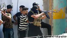 An armed member of Saraya al-Salam (Peace Brigade), the military wing affiliated with Shiite cleric Moqtada al-Sadr, fires during clashes with Iraqi security forces in Baghdad's Green Zone on August 30, 2022. - Fighting between rival Iraqi forces resumed in Baghdad, where 23 supporters of Shiite leader Moqtada Sadr have been shot dead since Monday, according to the latest toll by medics. Clashes between Sadr's supporters and the army and men of the Hashed al-Shaabi, former paramilitaries integrated into the Iraqi forces, had calmed down overnight but resumed again on this morning. (Photo by Ahmad Al-rubaye / AFP) (Photo by AHMAD AL-RUBAYE/AFP via Getty Images)