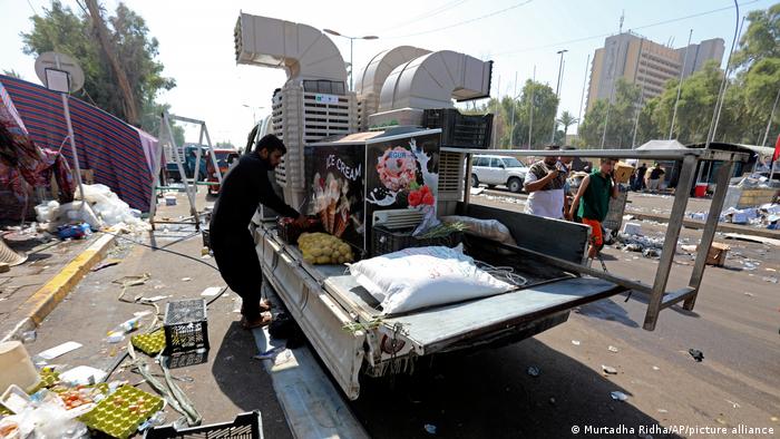 A supporter of Iraqi cleric Moqtada al-Sadr removes a food stand as the protesters withdraw from outside the parliament building inside Baghdad.