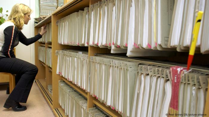 woman looking through archive of paper files in Berlin government agency