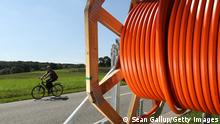 ***Archivbild: 23.8.17***HALDENSLEBEN, GERMANY - AUGUST 23: A man on a bicycle rides past a spool of tubing used for laying fiber optic cable underground during the installation of broadband infrastructure in the village of Bebertal by a private company called MDDSL on August 23, 2017 near Haldensleben, Germany. The German government is subsidizing efforts to improve broadband access in rural areas. Germany faces elections on September 24 and rural development is a strongly political issue. Many rural areas in Germany, especially in the eastern parts, are facing challenges, especially due to demographics. (Photo by Sean Gallup/Getty Images)