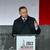 Polish President Andrzey Duda, speaking at a podium in front of a large, vertical Polish flag