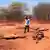 Kenia Dürre Ein Mann steht in einer trockenen Region an der Grenze zu Äthiopien, auf rotem Sand liegen tote Rinder 