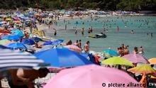 Menschen schwimmen und sonnen sich am Strand Cala Agulla nahe Cala Rajada auf Mallorca. Noch immer herrschen hier hohe Temperaturen und Hitzewarnungen. +++ dpa-Bildfunk +++