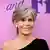 US-Schauspielerin Jane Fonda steht vor einer pinken Wand und lächelt in die Kamera.