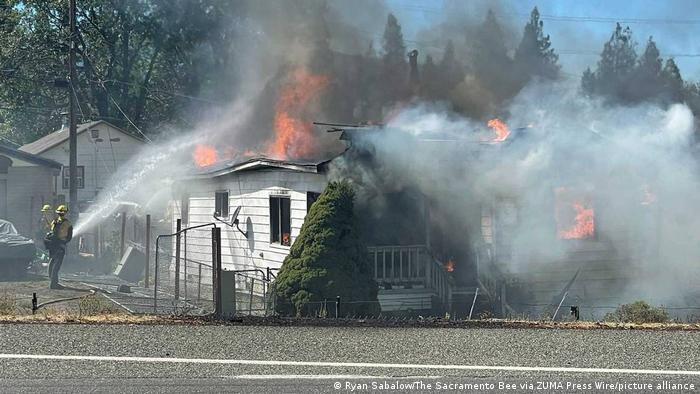 Los bomberos luchan contra las llamas en una casa quemada por el incendio Mill cerca de Weed, California, el viernes 2 de septiembre de 2022. 