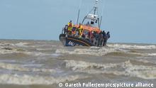 Migrant Channel crossing incidents. File photo dated 13/09/21 of a group of people thought to be migrants being brought in to Dungeness, Kent, by the RNLI, following a small boat incident in the Channel. More than 28,300 people crossed the English Channel to the UK aboard small boats in 2021, triple the number for 2020. Issue date: Tuesday January 4, 2022. Last year's record number - an increase of around 20,000 on 2020 - came despite millions of pounds promised to French authorities to tackle the issue. The last 12 months have also seen a trend of smugglers packing more and more people aboard larger and larger dinghies, sometimes with deadly consequences. See PA story POLITICS Migrants. Photo credit should read: Gareth Fuller/PA Wire URN:64580974