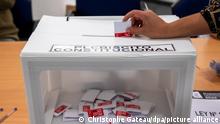 Zur Wahl um das Verfassungsreferendum in Chile steckt eine Frau in der Chilenischen Botschaft einen Stimmzettel in eine Urne. +++ dpa-Bildfunk +++
