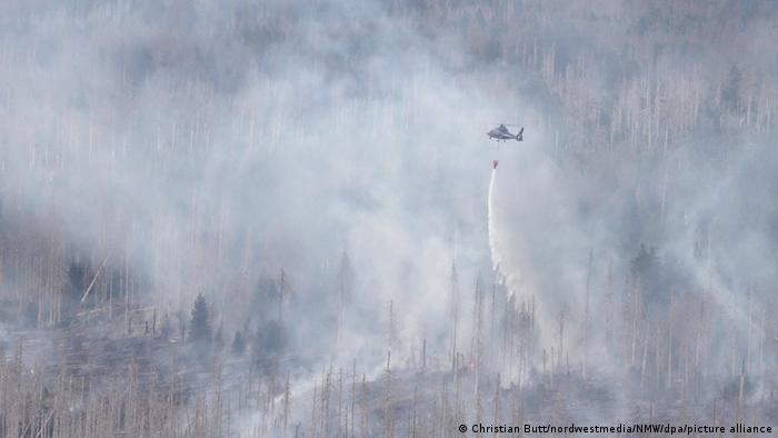 Un hélicoptère de lutte contre les incendies largue de l'eau sur un incendie de forêt sur la montagne Brocken, dans le nord de l'Allemagne, le 4 septembre 2022