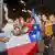 Personas celebran con banderas de Chile el triunfo del rechazo. 