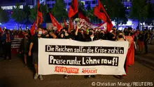 People take part in a left-wing protest against increasing energy prices and rising living expenses in Leipzig, Germany, September 5, 2022. The banner reads: Let the rich pay for the crisis. Prices down, wages up!. REUTERS/Christian Mang