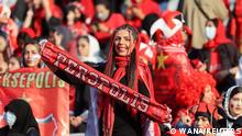 A Persepolis fan holds the team's scarf at a match between Persepolis and Sanat Naft-e Abadan in Iran's Premier League at Azadi stadium in Tehran, Iran August 31, 2022. Majid Asgaripour/WANA (West Asia News Agency) via REUTERS ATTENTION EDITORS - THIS IMAGE HAS BEEN SUPPLIED BY A THIRD PARTY.