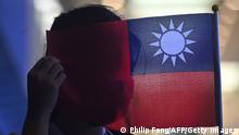 A woman holds a Taiwanese flag to cover her face as as she joins others at a rally to mark Taiwan's National Day, in the Tsim Sha Tsui district in Hong Kong on October 10, 2019. - Taiwan's National Day, also called called Double-Ten in a reference to the nationalist Republic of China set up by Sun Yat Sen on October 10, 1911, ending centuries of Chinese dynastic rule. (Photo by Philip FONG / AFP) (Photo by PHILIP FONG/AFP via Getty Images)