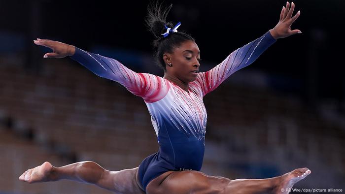 US gymnast Simon Biles performs a jump split on the balance beam.  The multiple Olympic champion is a victim of sexualised violence and sought to make it public with her teammates.