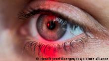 ILLUSTRATION - Das Auge eine Frau wird am 01.07.2016 in Berlin von einem roten Licht angestrahlt. Foto: Henrik Josef Boerger