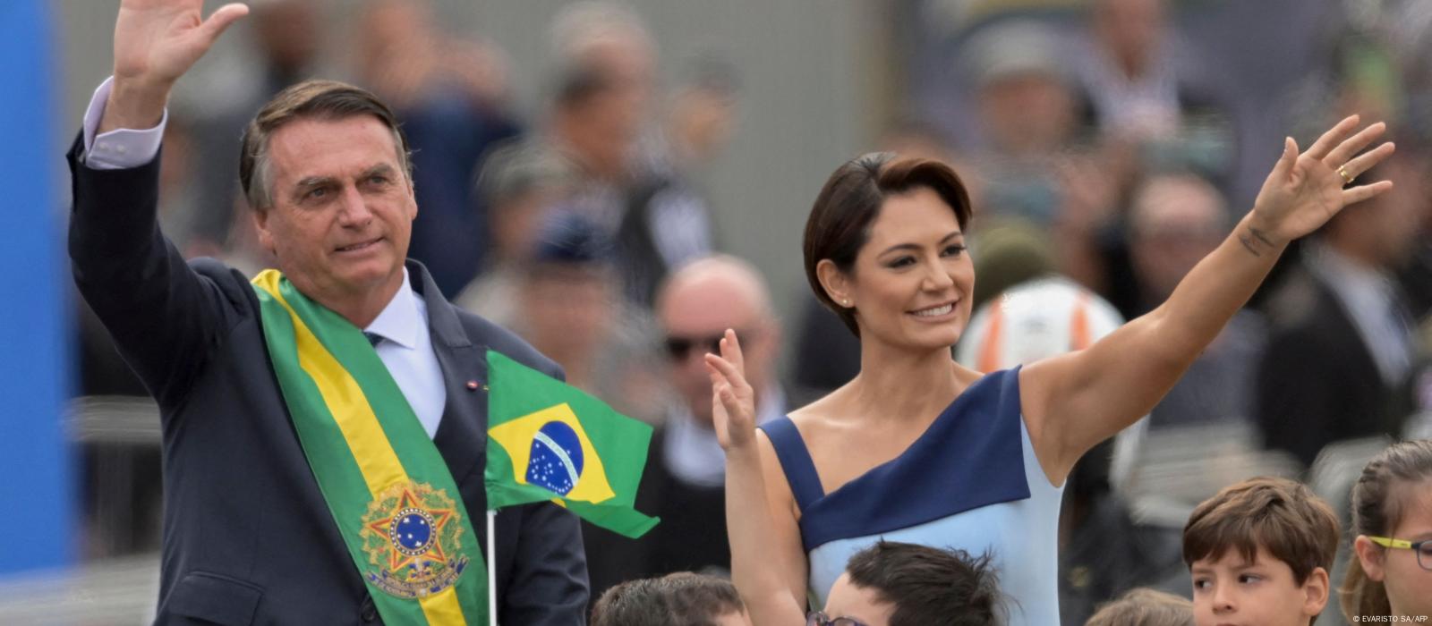 Bolsonaro e sua mulher, Michelle, acenam para o público em desfile