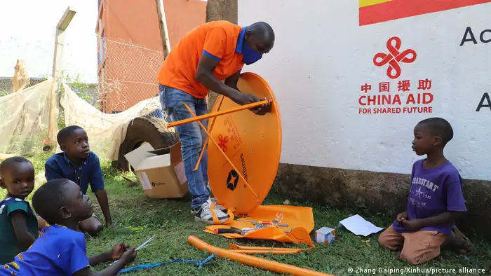 在乌干达的一间村落，中国四达时代的一名当地员工正在安装一台卫星电视接收设备 (2021年9月)