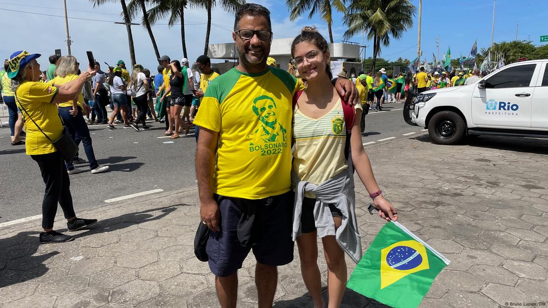 Marcelo Câmara com camiseta com rosto de Bolsonaro na orla e ao lado de mulher