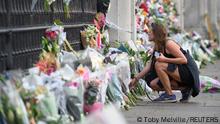 A woman places flowers at Buckingham Palace, following the passing of Britain's Queen Elizabeth, in London, Britain, September 9, 2022. REUTERS/Toby Melville
