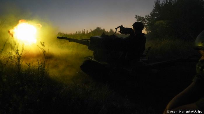 Soldados ucranianos disparan un cañón en las primeras horas del día.