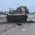 Un coche pasa por delante de un vehículo blindado destruido en Balakliya, región de Jarkóv, en medio de la invasión rusa de Ucrania. 