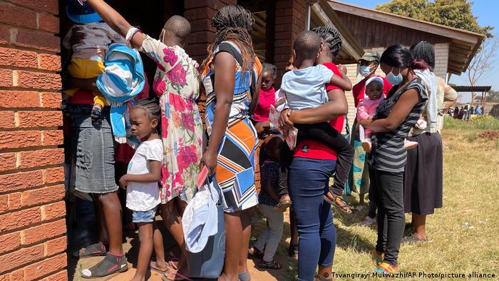 Mothers waiting in line to get their their children vaccinated against measles at a local clinic in Harare