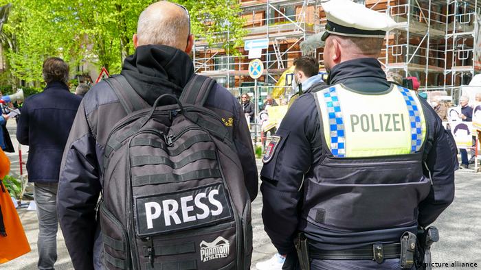 Un policía acompaña a un periodista en Hamburgo