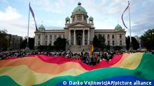 FILE - Participants carry large rainbow flag in front of the parliament building as they take part in the annual LGBT pride march in Belgrade, Serbia, Saturday, Sept. 18, 2021. Serbia's police on Tuesday banned an international Pride march that is to be held later this week, citing a risk of clashes between gay rights activists and far-right opponents of a pan-European LGBTQ events planned for this week in Belgrade. (AP Photo/Darko Vojinovic, File)