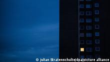 A high-rise apartment block with one lighted window