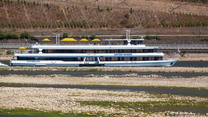 A passenger ship travels at low tide on the Rhine.