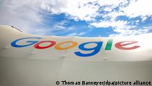 Ein Schriftzug des Technologieunternehmens Google ist auf einem Zeltdach auf der Digitalkonferenz Digital X der Deutschen Telekom zu sehen.