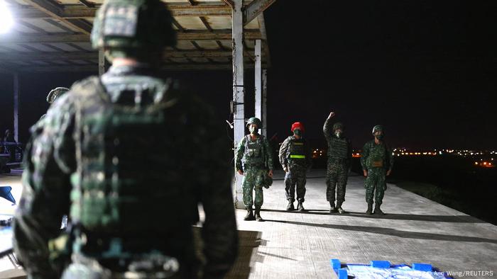 Un soldado taiwanés de espaldas desenfocado en primera plano y otros cuatro al fondo, durante unas maniobras militares.