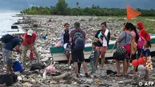 A Guatemalan family prepares to board a boat on a beach full of plastic residues and other waste in Omoa, Honduras, on September 11, 2022. - Dragged by different tributaries, immense multicolored plastic deposits cover the calm waters of Lake Suchitlan in El Salvador like a blanket. The same thing happens on the paradisiacal beaches of the Honduran Caribbean, which receive thousands of tons of waste from Guatemala. (Photo by ORLANDO sierra / AFP)