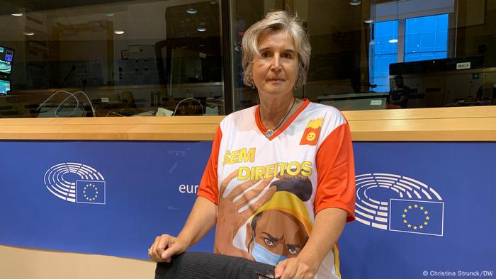 A woman standing behind a chair, wearing a T-Shirt showing a McDonald's employee