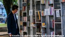 (220423) -- MANILA, April 23, 2022 (Xinhua) -- A man looks at books at the Book Stop at a plaza on the World Book Day in Manila, the Philippines on April 23, 2022. The Book Stop in Manila is a pop-up library with the slogan give a book, get a book to encourage people to read and promote the sharing of ideas through the redistribution of books. (Xinhua/Rouelle Umali)