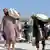 Afghan men carrying sacks of food aid