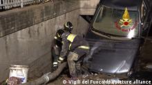 Feuerwehrleute schieben einen Schlauch in eine Tiefgarage, die durch hochgestelltes Auto versperrt ist. Heftige Regenfälle und Überschwemmungen an der italienischen Adriaküste haben Menschenleben gefordert, weitere Personen werden vermisst. +++ dpa-Bildfunk +++