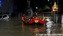 Rescue workers arrive on a dinghy boat on a flooded street after heavy rains hit the east coast of Marche region in Senigallia, Italy, September 16, 2022. Vigili del Fuoco/Handout via REUTERS ATTENTION EDITORS THIS IMAGE HAS BEEN SUPPLIED BY A THIRD PARTY. DO NOT OBSCURE LOGO. 