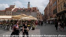 Tourists stroll on a street in the Warsaw Old Town area in the capital of Poland on June 8, 2022. Poland has supported the Ukrainian people who fled from their country, invaded by the Russian troops on February 24. ( The Yomiuri Shimbun via AP Images )