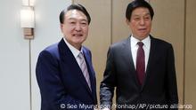 South Korean President Yoon Suk Yeol, left, shakes hands with Li Zhanshu, chairman of the standing committee of China's National People's Congress, at the presidential office in Seoul, South Korea, Friday, Sept. 16, 2022. (See Myung-gon/Yonhap via AP)