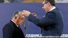 Hungary's Prime Minister Viktor Orban, left, receives the Order of Serbia from Serbian President Aleksandar Vucic in Belgrade, Serbia, Friday, Sept. 16, 2022. Orban is on a one day working visit to Serbia. (AP Photo/Darko Vojinovic)