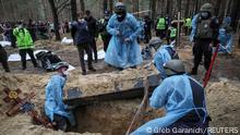 Members of Ukrainian Emergency Service, police and experts work at a place of mass burial during an exhumation, as Russia's attack on Ukraine continues, in the town of Izium, recently liberated by Ukrainian Armed Forces, in Kharkiv region, Ukraine September 16, 2022. REUTERS/Gleb Garanich