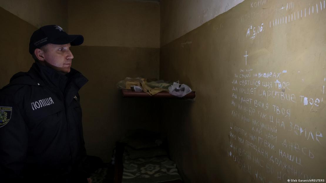 Policial observa escritos em uma parede
