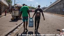 PORT-AU-PRINCE, HAITI - SEPTEMBER 15: People carry a gas cylinders to refill as protesters continue demonstration on the third day of mobilization over fuel price hikes in Port-au-Prince, Haiti on September 15, 2022. Georges Harry Rouzier / Anadolu Agency