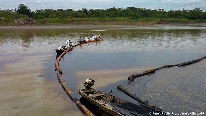 Foto de personas que intentan parar el derrame de petróleo en el río Cuninico de Perú.