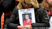 A well-wisher holds a portrait of Queen Elizabeth II as she waits along the Procession route in London on September 19, 2022, ahead of the State Funeral Service of Britain's Queen Elizabeth II. - Leaders from around the world attended the state funeral of Queen Elizabeth II. The country's longest-serving monarch, who died aged 96 after 70 years on the throne, was honoured with a state funeral on Monday morning at Westminster Abbey. (Photo by LOUISA GOULIAMAKI / AFP)