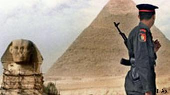 An Egyptian soldier stands guard in front of the Great Pyramids and the Sphinx