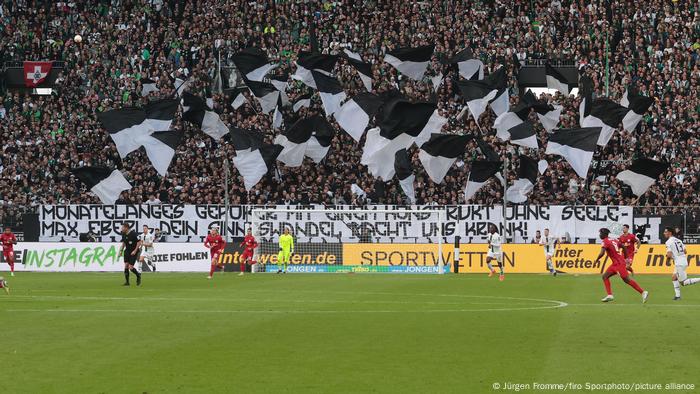 The picture shows a banner in the curve of the Mönchengladbach fans in the stadium.  It reads: Months of retching with a construct without a soul - Max Eberl, your change of heart is making us sick. 