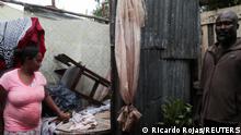 A man and a woman stand inside their destroyed house in the aftermath of Hurricane Fiona in Higuey, Dominican Republic, September 19, 2022. REUTERS/Ricardo Rojas