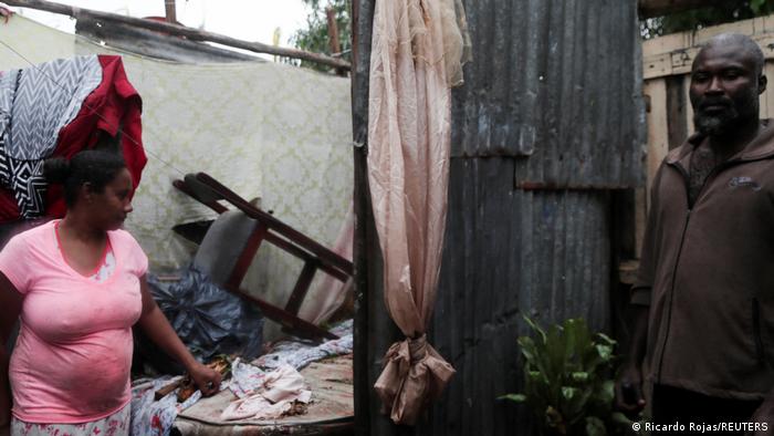 A man and a woman stand inside their destroyed house in the aftermath of Hurricane Fiona in Higuey, Dominican Republic